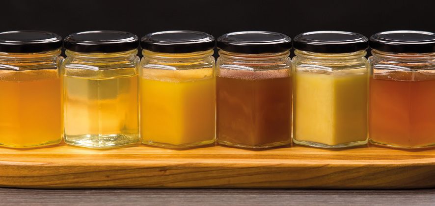 Hexagonal jars with different types and colors of fresh flower honey. vitamin food for health and life